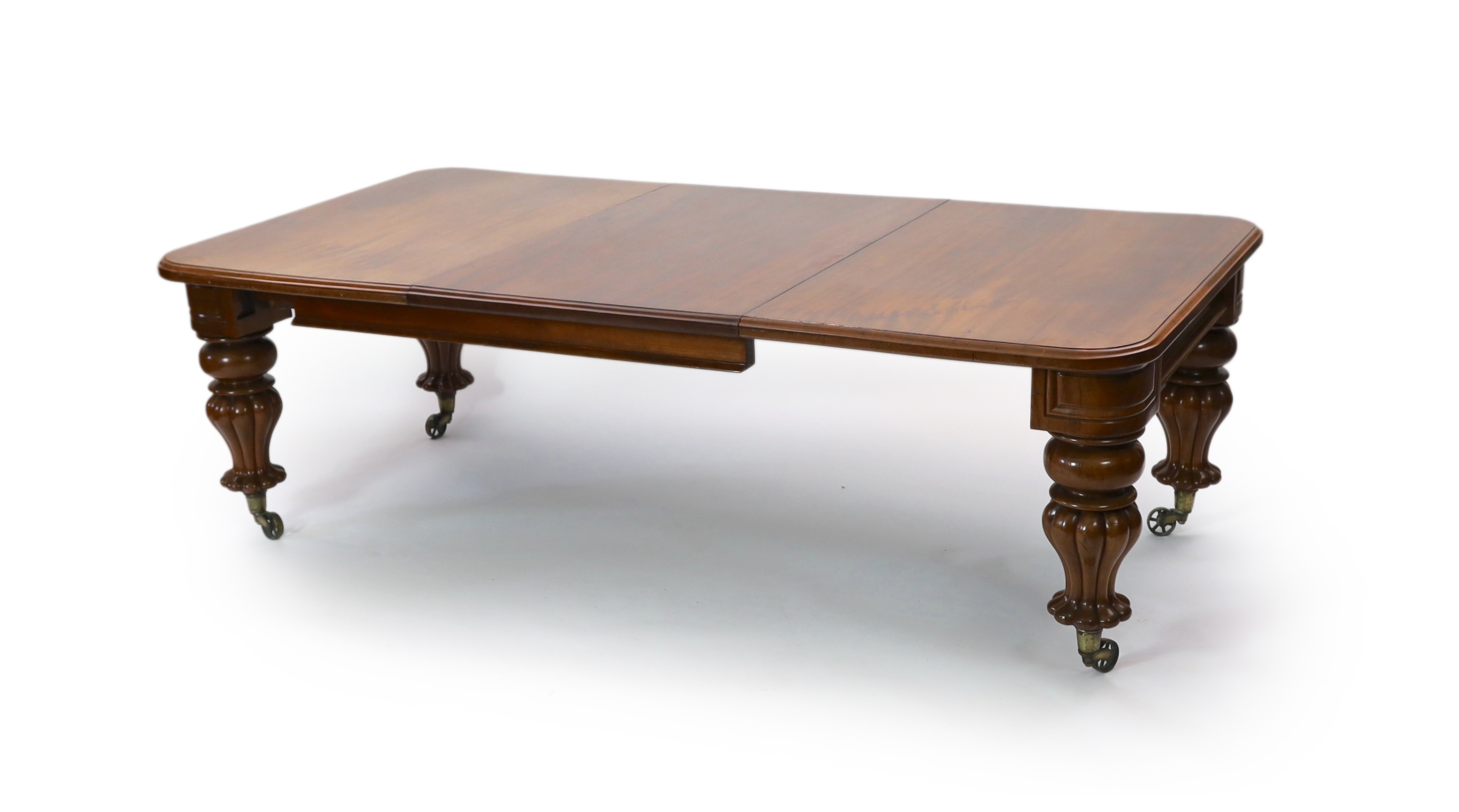 A mid Victorian mahogany extending dining table, on fluted baluster legs and spoked brass castors, 355cm extended, three spare leaves, width 118cm height 73cm